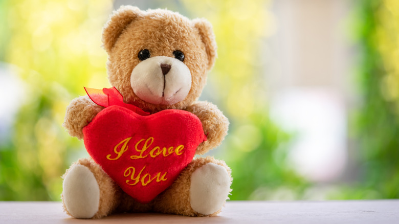 A teddy bear holding a heart that says "I love you."