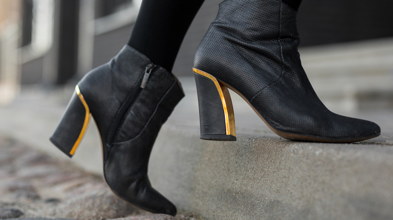 Person in black thick-heeled boots