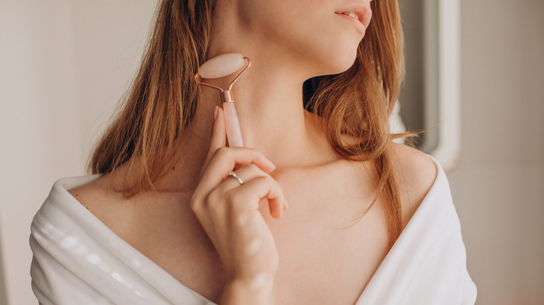 A woman using a facial roller