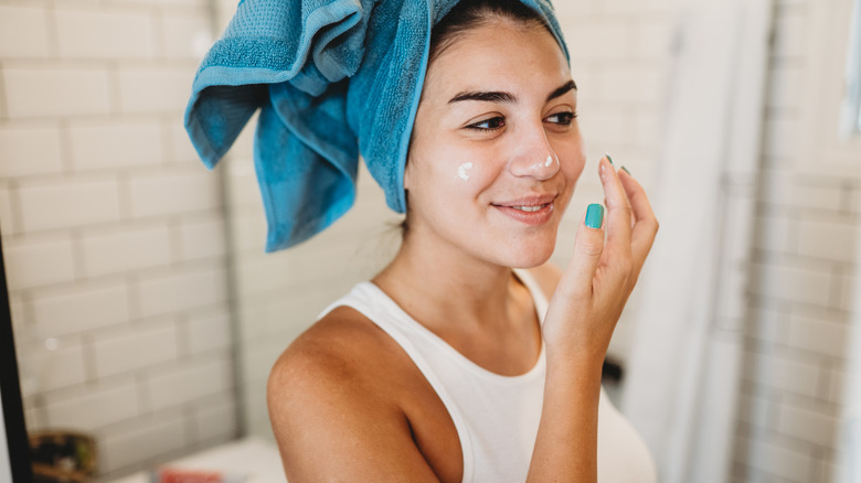 A woman applying skincare