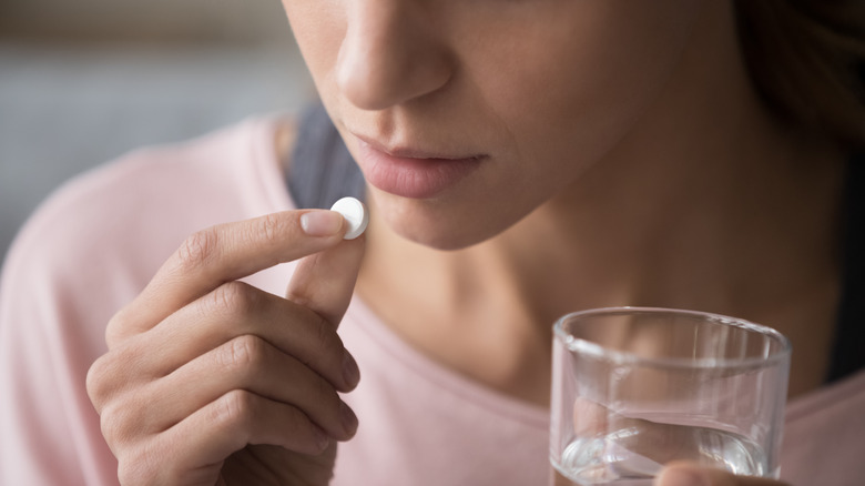 A woman taking a pill