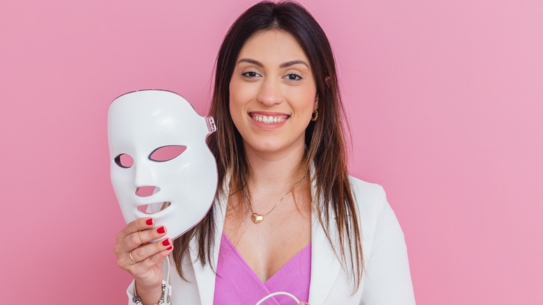 woman holding light therapy mask