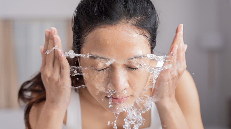 A woman splashing water on her face