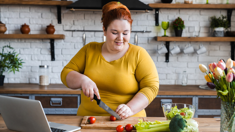 Woman chopping tomatoes for salad