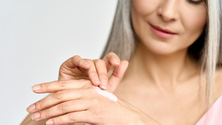 Woman applying night cream from the back of her hand