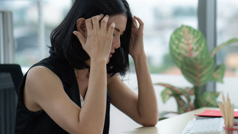 Stressed woman with hands on head