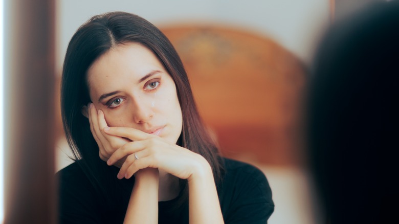 Sad woman resting head on hands