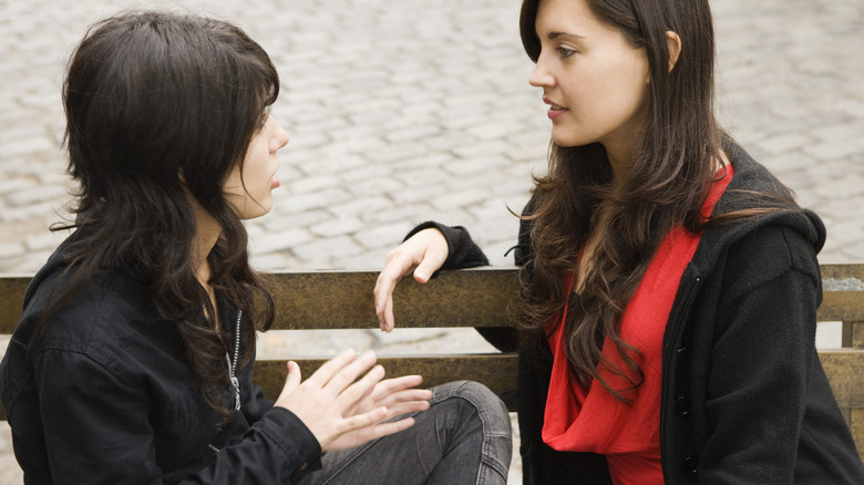 Two women talking on bench