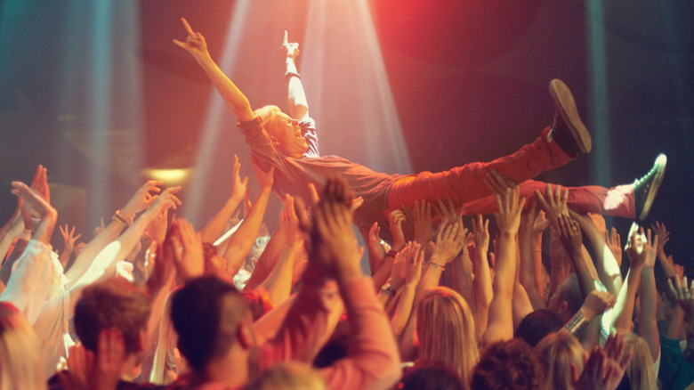 Person crowdsurfing at concert