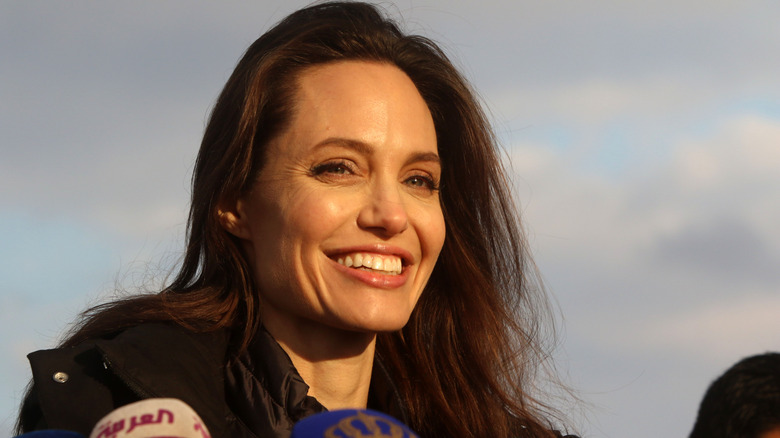 Angelina Jolie smiles with minimal makeup.