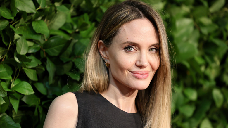 Angelina smiling with natural makeup and blond hair.