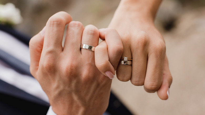 Entwined hands with wedding rings