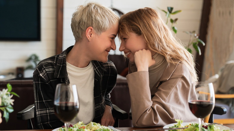 LGBTQ+ lesbian couple having dinner and wine