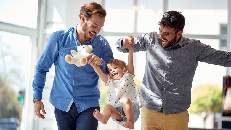 Gay couple playing with their child