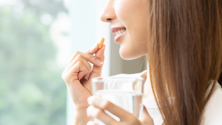 woman drinking tablet