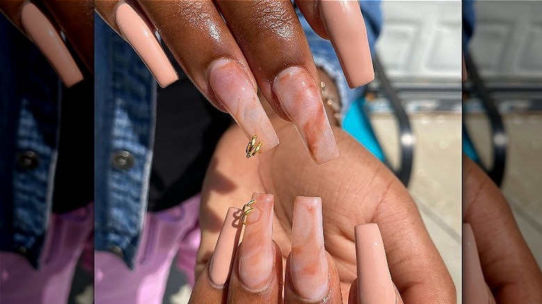 person with long pierced nails