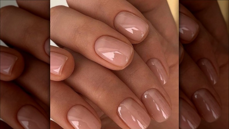 person with glossy nude nails 