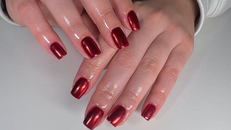 person with red chrome nails 