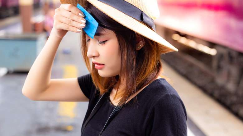 woman blotting oily forehead