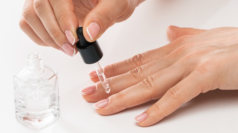person applying cuticle oil