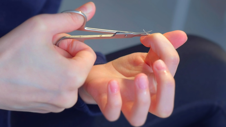 woman using cuticle scissors