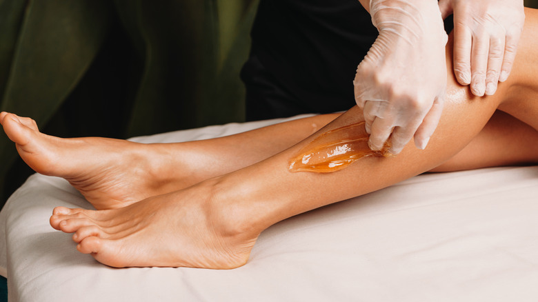 woman sugaring their legs