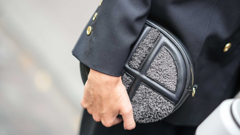 woman holding fuzzy clutch