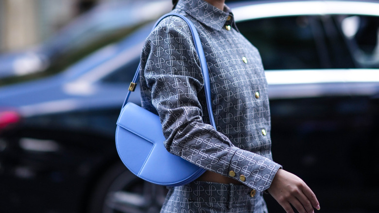 woman holding blue shoulder bag