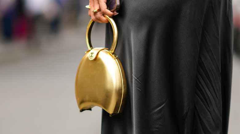 woman holding gold bag