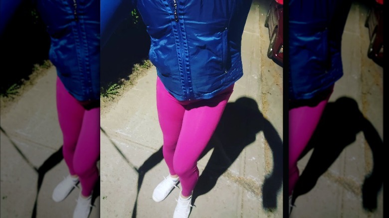 Woman poses in hot pink leggings