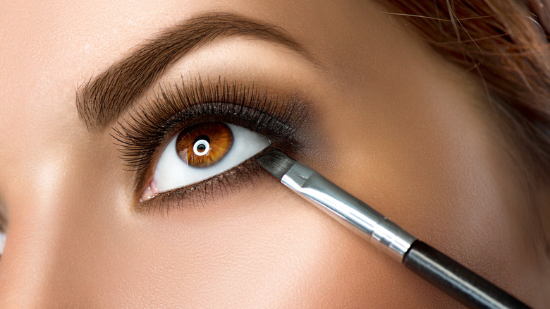 Brown eyed woman with makeup brush 