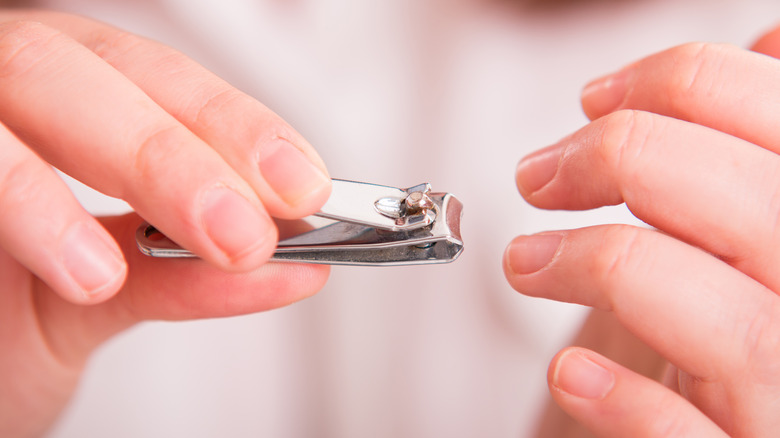 person cutting fingernails with clippers