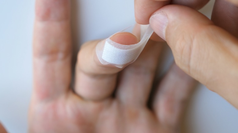 putting white bandage around nail