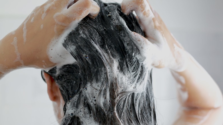 woman washing hair with shampoo