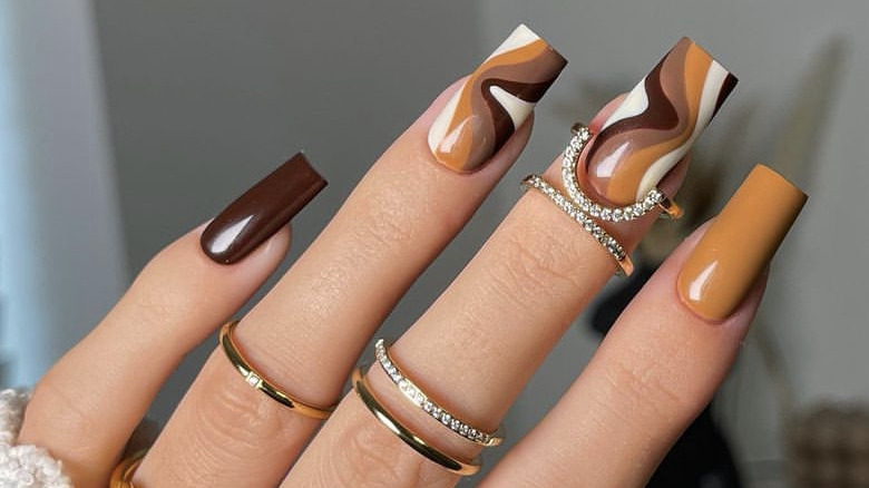 fingers with brown swirl nails