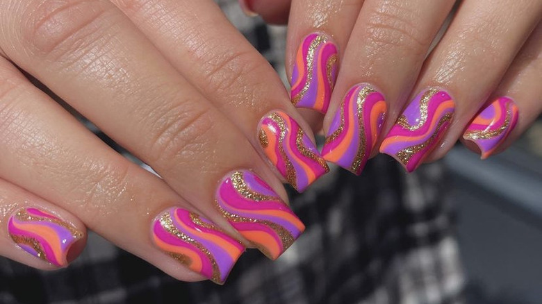 fingers with pink swirl nails 