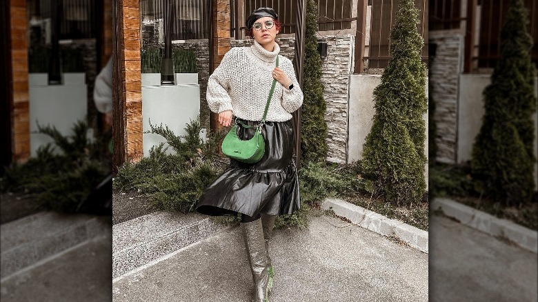 Woman poses with kelly green handbag 