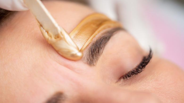 Person having eyebrows waxed