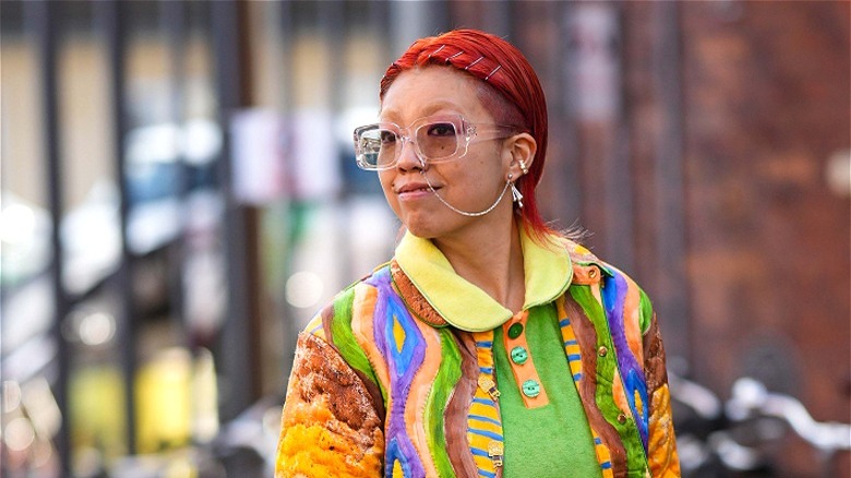 Person with bright red hair and colorful clothes