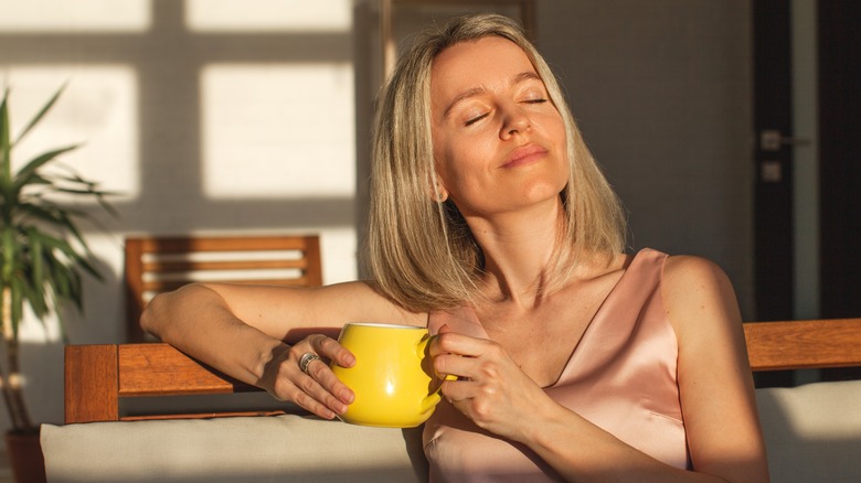 woman drinking coffee in sun