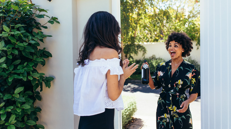 person gifting bottle of wine