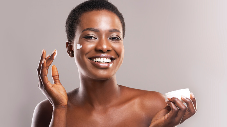 Woman applying moisturizer to her face