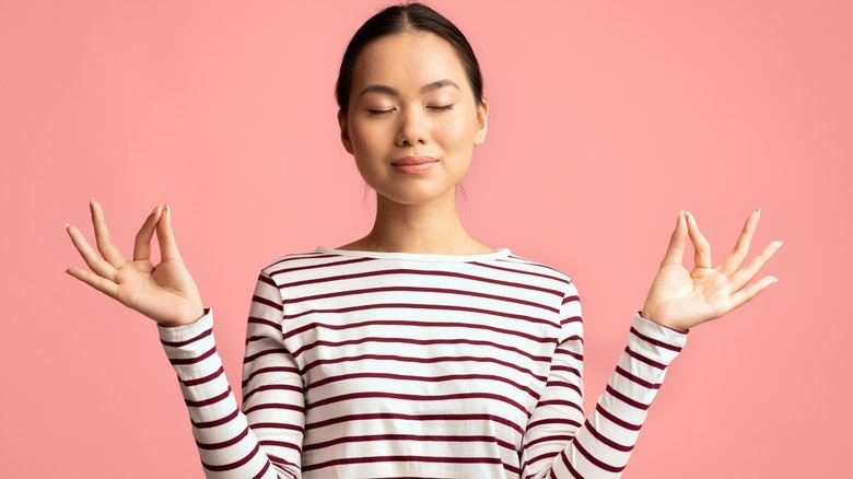 Young woman with peaceful expression in meditation pose