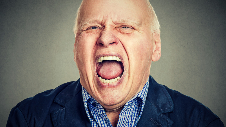 Close up of the face of an older man yelling