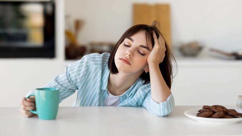 Tired woman drinking coffee