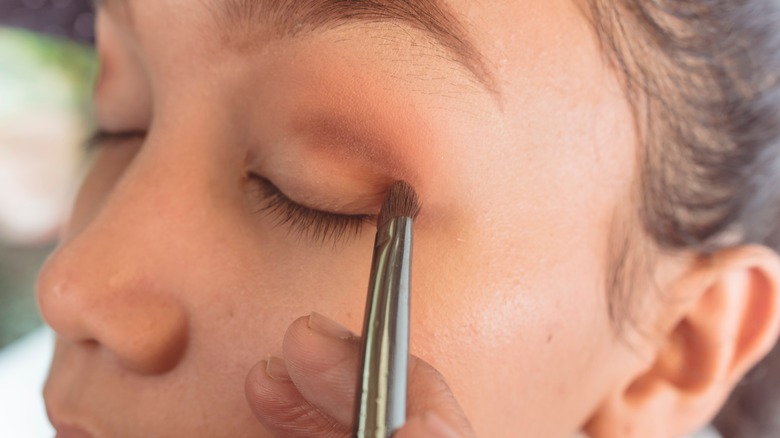 A woman applying eyeshadow