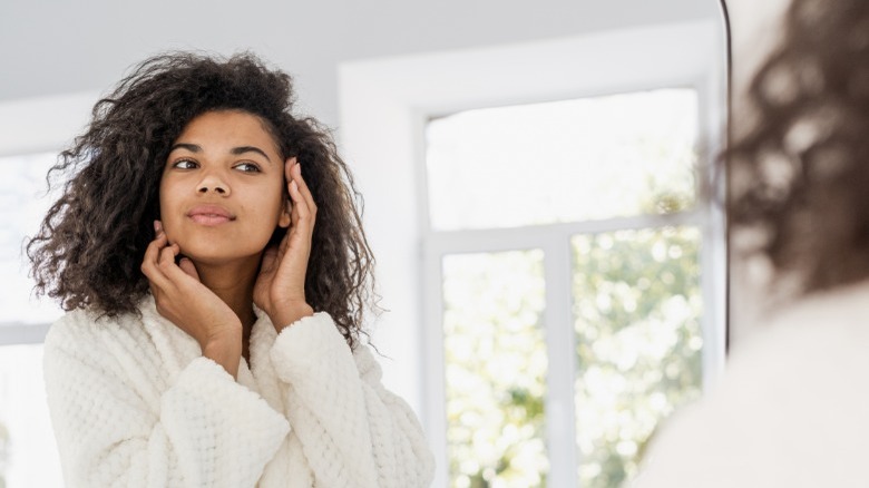 Woman looking at herself in mirror