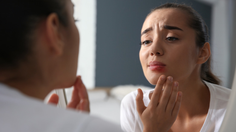 woman looking at lip redness