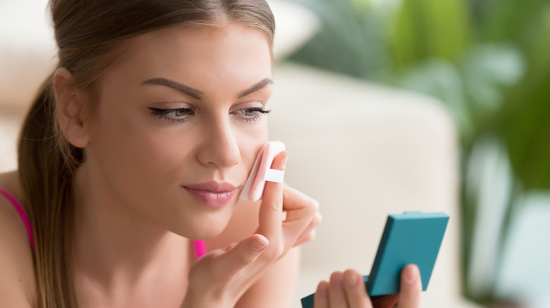 Woman touching up her makeup