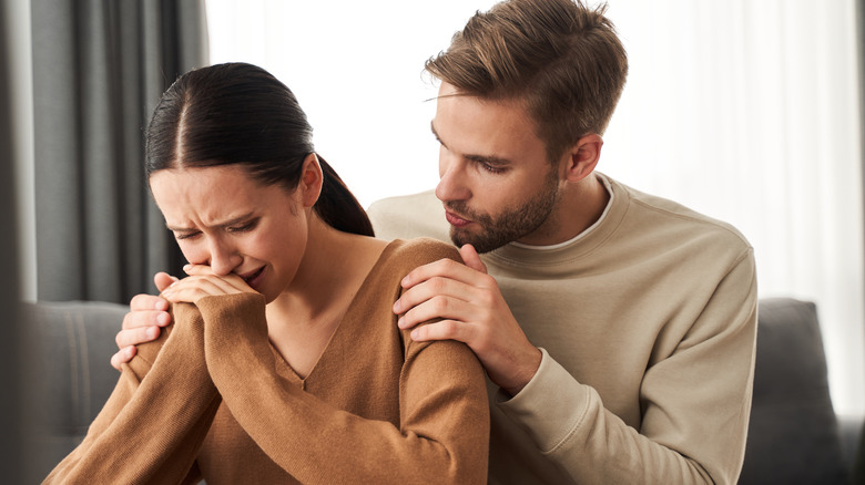 Man consoling woman